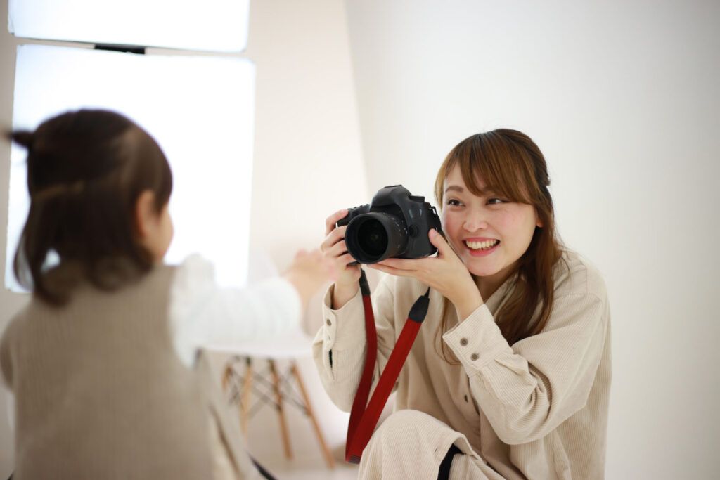 a woman holding a camera to a child