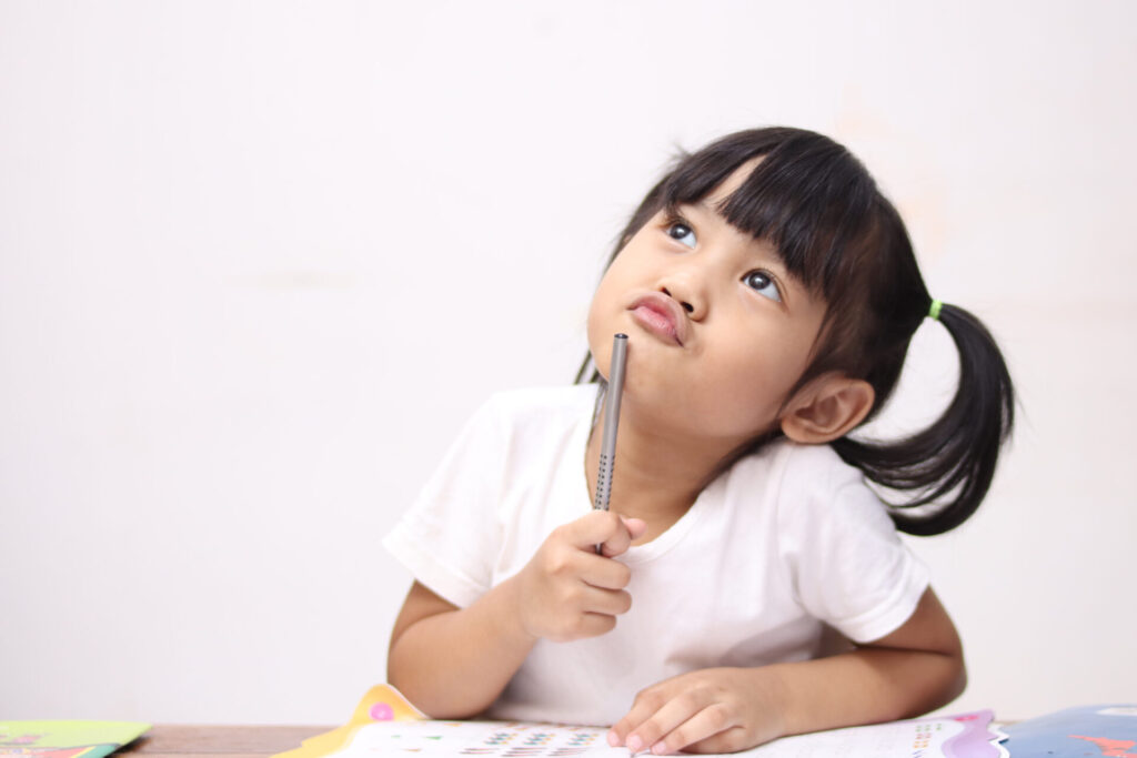a girl with pigtails holding a pen