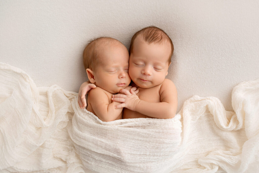 two babies sleeping in a blanket